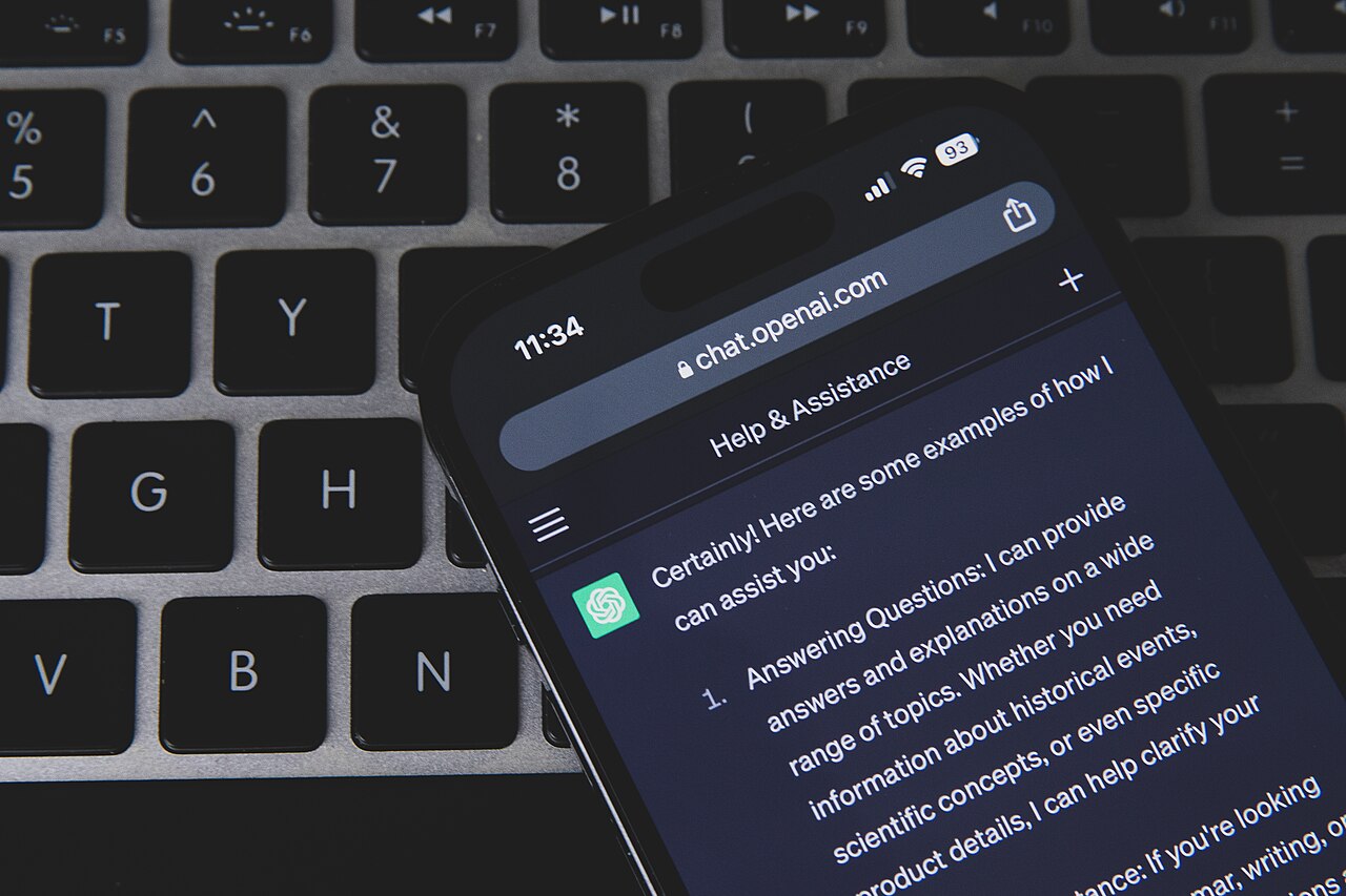 Смартфон із відкритим ChatGPT на клавіатурі ноутбука; ілюстративне фото, не інтерфейс dots