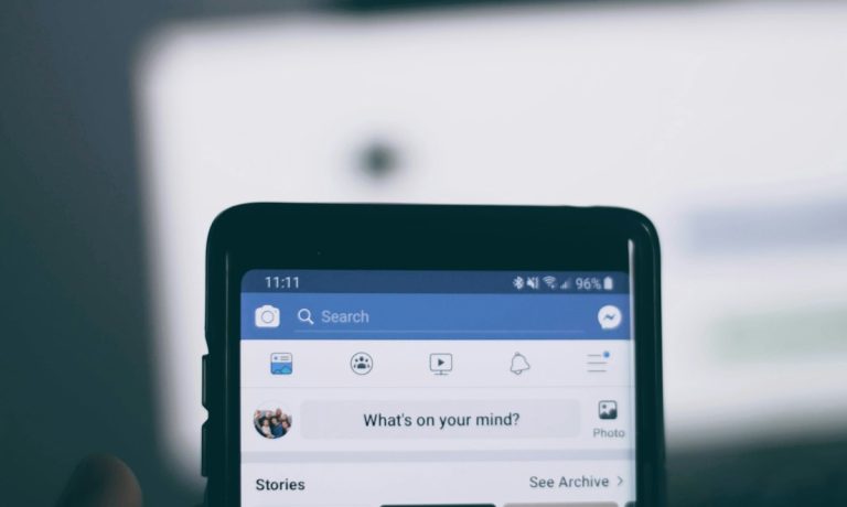 Людина тримає смартфон із відкритим Facebook, ілюстрація до обмеження посилань