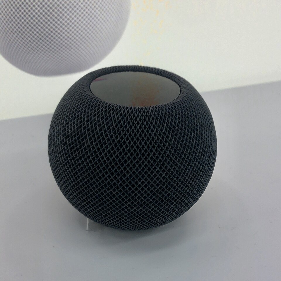 Чорна колонка HomePod mini першого покоління на світлому стенді