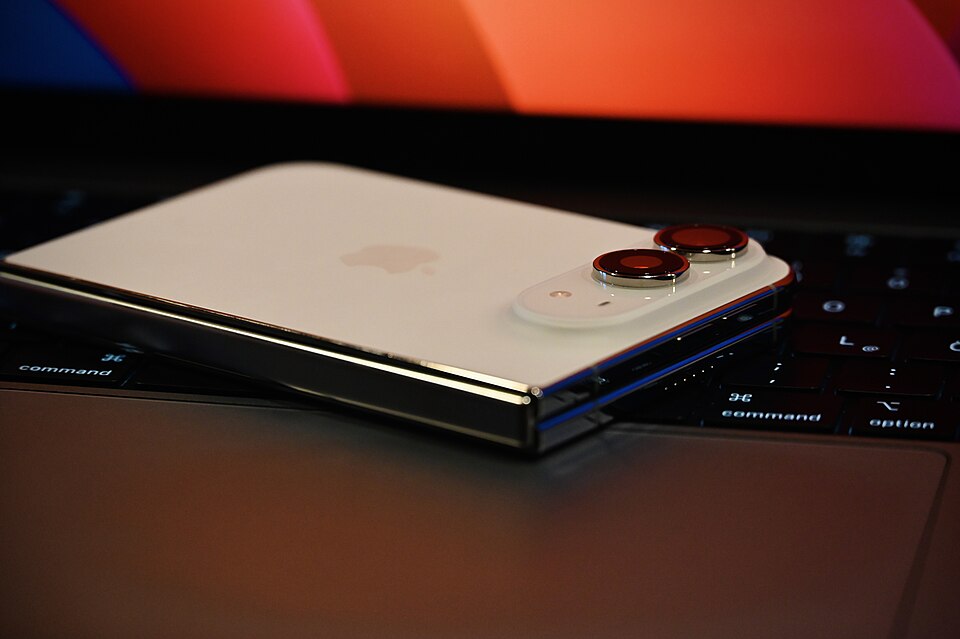 Складений iPhone Duo лежить на ноутбуці, видно шарнір і дві задні камери