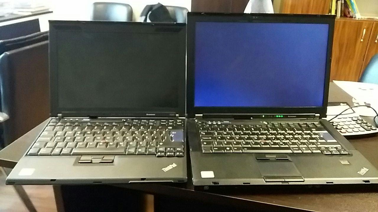 Два старі ноутбуки Lenovo ThinkPad X200 та T400 поруч на столі